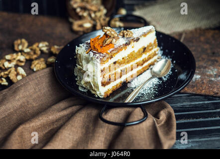 Stück Karottenkuchen mit Frischkäse und Walnüssen. Das Restaurant oder Café-Atmosphäre. Jahrgang Stockfoto