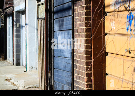 Gasse zurück. Gegenüberstellung von bunten Garagentore und verschiedener Strukturen in einer Gasse hinter Häusern in einer Innenstadt von Toronto Nachbarschaft. Stockfoto