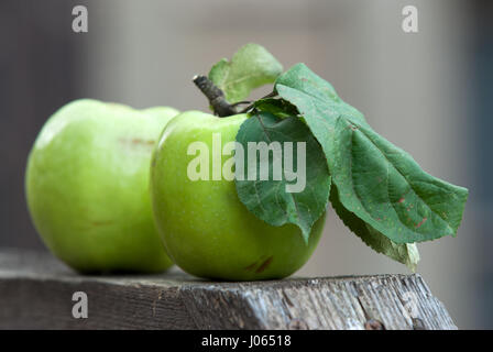 Zwei grüne Äpfel auf einer Holzoberfläche Stockfoto