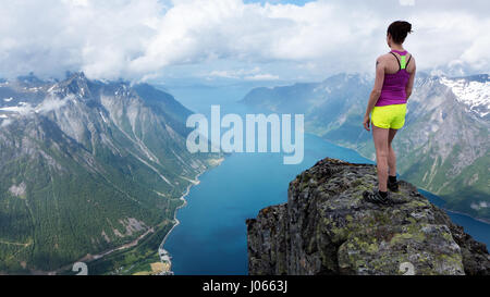 Ein Fotograf Freundin steht an der Spitze eines Berges. ATEMBERAUBENDE Bilder zeigen einen weiblichen Bergsteiger gefährlich über den Wolken stehen. Die Sammlung von spektakulären Aufnahmen zeigt ein Fotograf Freundin aufstehen bei 5.000 Fuß während mit Blick auf den wunderschönen norwegischen Fjorden. Andere Bilder zeigen ihr hocken auf einem Felsvorsprung, als ob sie am Anfang der Welt sitzt. Norwegische Lagerarbeiter Johan Kistrand (33) ging bis zu fünf Stunden an jeden Ort, die schönen Bildern zu erfassen. Begleitet von seiner Freundin, die auch in den Aufnahmen bietet, wurden die Standorte i Stockfoto