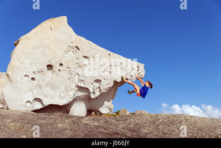 Ein Mädchen auf einem Felsen in Calvi klettern. Korsika ist die gebirgigste Insel im Mittelmeer und liegt im Westen von Italien, Südosten des französischen Stockfoto