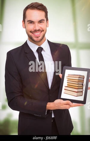 Lächelnd Geschäftsmann seinen Tablet-pc gegen Klebstoff Notizen auf Fenster zeigen Stockfoto