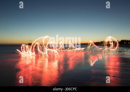 BRASILIANISCHE MITTELLAND, Brasilien: Feuerwerk haben verwendet, um einzigartige Kunstwerke schaffen, die Vergänglichkeit des Lebens darstellt. Die Serie namens "Einheiten" zeigt feurig orange wirbelt und Streifen gegen natürliche Einstellungen überlagert.  Lichtmuster lässt sich über dem Wasser tanzen, Felsen und sand sowie mächtigen alten Bäumen in ein spektakuläres Feuerwerk. Brasilianische Fotograf Vitor Schietti (30) schuf dieses leuchtende Kunstwerk in seinem Heimatland mit der brasilianischen Mittelland als seinen Hintergrund. Stockfoto