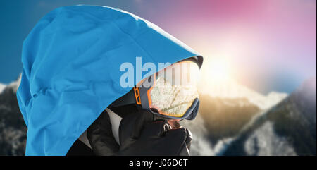 Nahaufnahme des Skifahrers telefonieren mit Handy gegen verschneite Gebirge gegen blauen Himmel Stockfoto