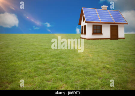 3D Abbildung des Hauses mit Sonnenkollektoren gegen malerischen Blick auf blauen Himmel Stockfoto