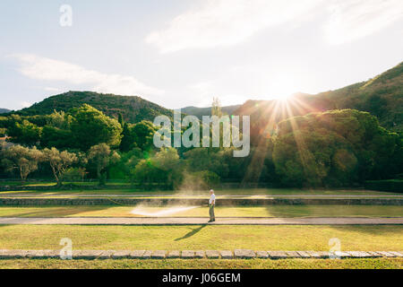Der Gärtner gewässert Rasen aus dem Schlauch. Gebiet des Parks Milocer in Montenegro. Stockfoto