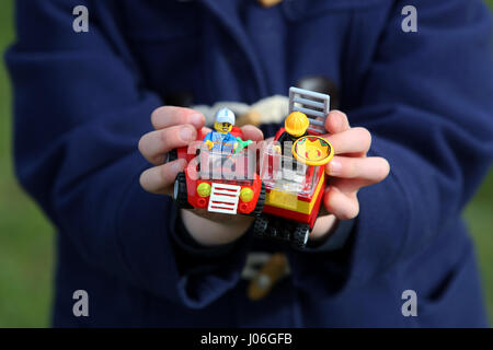 Ein junges Mädchen abgebildet draußen spielen mit Lego in einem Park in Chichester, West Sussex, UK. Stockfoto