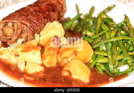 Hausgemachte Rindsroulade - Rindfleisch mit Senf, Speck, Gurke, Zwiebeln - gerollt, mit grünen Bohnen und Kartoffeln Stockfoto