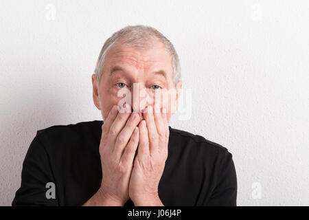 Verärgert senior Mann mit Kopfschmerzen, halten den Mund, Studio gedreht. Stockfoto