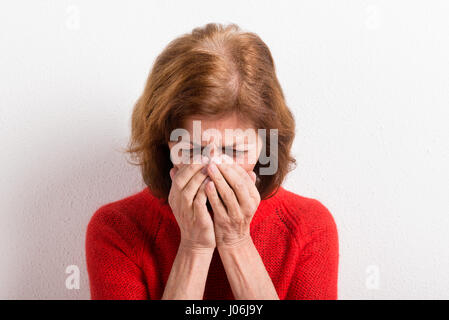 Ältere Frau Kopf haltend, mit Kopfschmerzen. Studio gedreht. Stockfoto