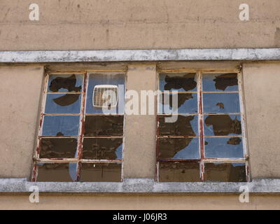 Zerbrochene Fensterscheiben am verfallenen Gebäude Stockfoto