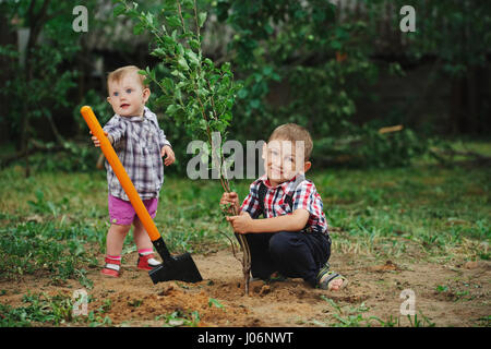 kleine lustige junge mit Schaufel im Garten Stockfoto