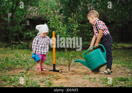 kleine lustige junge mit Schaufel im Garten Stockfoto