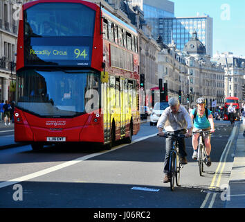 Radfahrer auf Busspur durch roten Doppeldecker-Bus in London Stockfoto