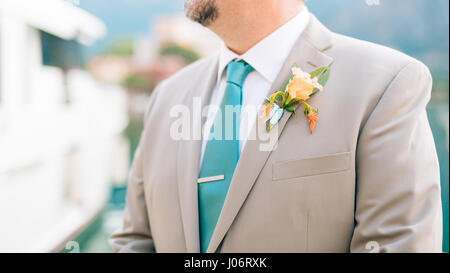 Der Bräutigam mit einem Bart Boutonniere am Revers eine leichte Jacke mit eine blaue Krawatte. Stockfoto