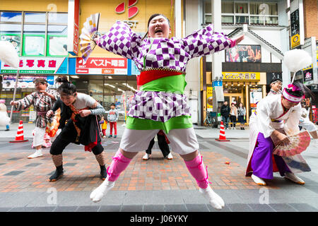 Japan, Kumamoto, Hinokuni Yosakoi Dance Festival. Teenage Frau Tänzer, hält das Gebläse, in Karomuster yukata, tanzen vor der Viewer. Close Up. Stockfoto