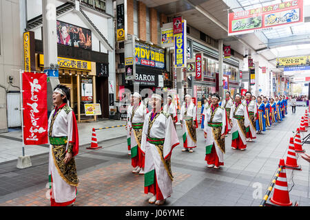 Japan, Kumamoto, Hinokuni Yosakoi Dance Festival. Tanz Team in aufwändigen und Yukata Kimono Kostüme, in 2 Zeilen, stehend in der Shopping Mall. Stockfoto