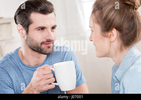 Schöne junge Paar trinken Tee zusammen und suchen sich gegenseitig Stockfoto