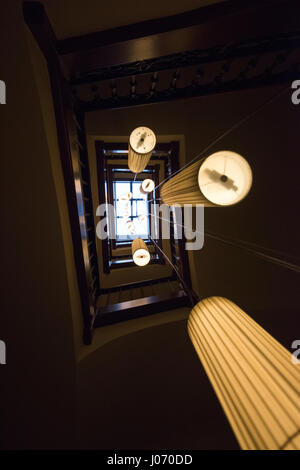 Über Ampeln hängen vom Zentrum einer Treppe in einem Wohnhaus in Barcelona Spanien EU nachschlagen Stockfoto