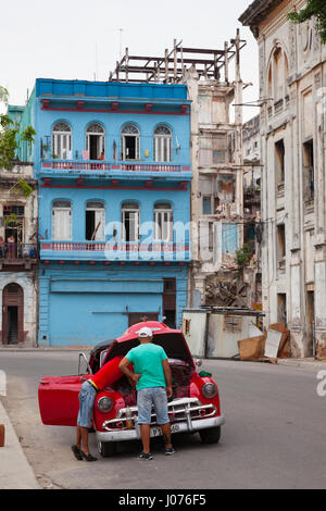 Zwei kubanische Männer reparieren ihr Auto mitten auf der Straße in Alt-Havanna, Kuba. Stockfoto