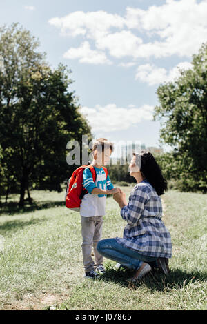 Mutter Abschied von ihrem Sohn Schuljunge auf Schulweg Stockfoto