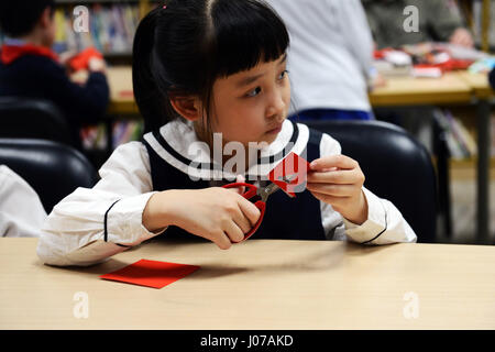 Kleine Kinder lernen die Kunst des Jianzhi - traditionelles Chinesisch Papier schneiden. Stockfoto