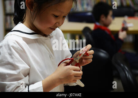 Kleine Kinder lernen die Kunst des Jianzhi - traditionelles Chinesisch Papier schneiden. Stockfoto