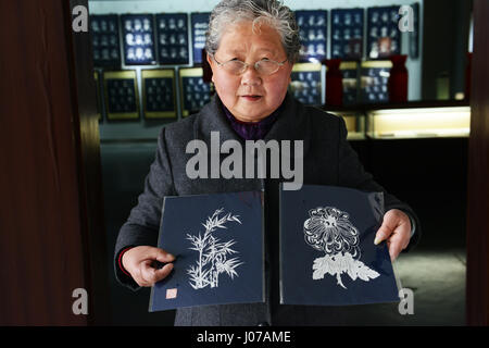 Ein berühmter Scherenschnitt Künstler Anzeigen ihrer Arbeit im Scherenschnitt Museum in Yangzhou, China. Stockfoto