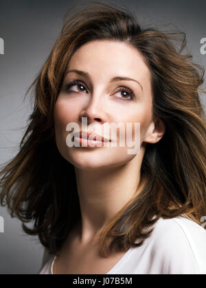 Führerschein erhältlich unter MaximImages.com - Porträt einer schönen lächelnden weißen Frau mit braunem Haar und Tagträumungsausdruck in den dreißiger Jahren Stockfoto