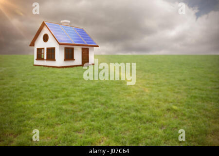 Digital zusammengesetztes Bild 3d Hauses mit Sonnenkollektoren gegen Himmel Stockfoto