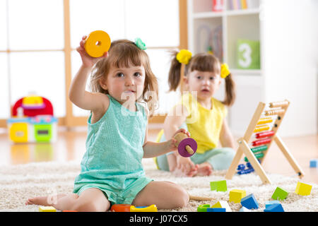 Kinder Kleinkinder und Vorschüler Mädchen spielen logische Spielzeug lernen Formen, arithmetische und Farben zu Hause oder im kindergarten Stockfoto