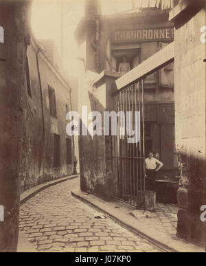 Eugène Atgets Fotografie „Metalworker's Shop, Passage de la Réunion“ zeigt ein typisches Pariser Metallwarengeschäft aus dem frühen 20. Jahrhundert. Das Bild zeigt das Arbeitsumfeld der Handwerker und zeigt das industrielle Handwerk und das Pariser Leben zu dieser Zeit. Stockfoto