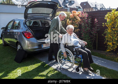 Senior Mann unter körperlich behinderte ältere Frau für eine Fahrt in ihrem Auto Stockfoto