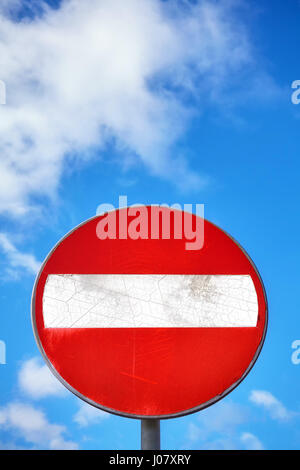 Geben Sie verwitterte Runde Zeichen nicht auf einen Metallpfosten gegen blauen Wolkenhimmel. Stockfoto