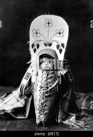 Edward S. Curtis’ Fotografie *People 007* ist Teil seiner umfangreichen Sammlung, die das Leben der Ureinwohner dokumentiert. Dieses Bild fängt ein Mitglied einer indigenen Gemeinschaft in traditioneller Kleidung ein, zeigt den kulturellen Reichtum und die würde des Themas und unterstreicht Curtis' Rolle bei der Bewahrung der Geschichte der Ureinwohner. Stockfoto