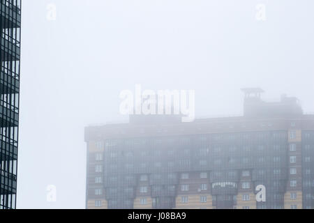 der Kran im Nebel auf den Bau von Häusern Stockfoto