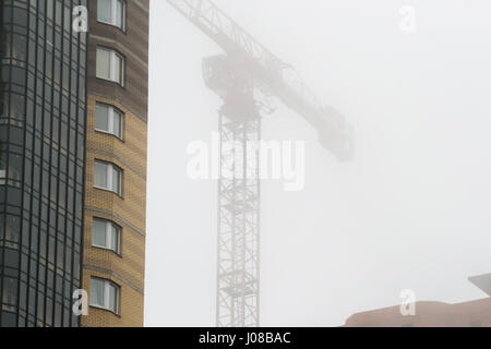 der Kran im Nebel auf den Bau von Häusern Stockfoto