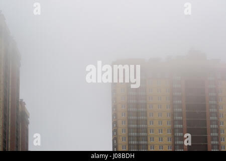 der Kran im Nebel auf den Bau von Häusern Stockfoto