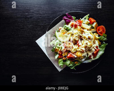 Caesar Salat mit Garnelen auf der hölzernen Tischplatte-Ansicht Stockfoto