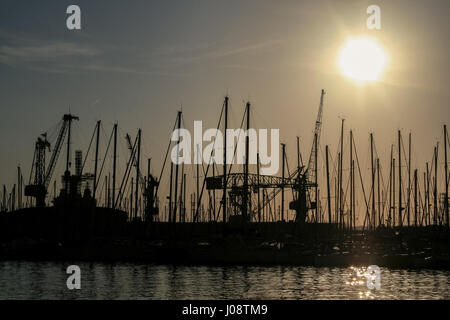 Form von Boot Masten und Krane bei Sonnenuntergang im Hafen von Toulon, Frankreich Bild Boote, Schiffe und Kräne in das Licht in der Dämmerung im Hafen von Toulon, Frankreich. Stockfoto