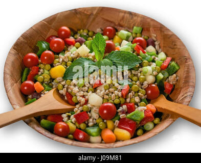 Salat mit Paprika, Dinkel, Erbsen, Frühlingszwiebeln und Regenbogen-Baby-Karotten, dekoriert mit Minze in verwittertem Holz Bambusschüssel, isolat Stockfoto