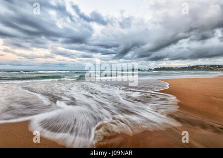 Dramatischen Blick auf einen drohenden Sturm und Wellen Motion blur bei Bombo Strand, Kiama, Illawarra Coast, New-South.Wales, NSW, Australien Stockfoto