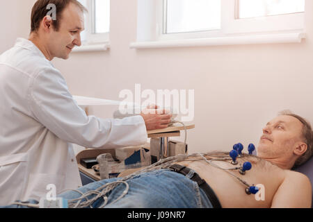 Angenehme Kardiologe sicherstellen, dass seine Patienten wohlfühlen Stockfoto