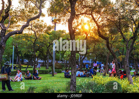 BANGKOK, THAILAND - 04. Februar: Chatuchak Park Bäume und Naturgebiet mit Menschen sitzen und entspannen auf dem Rasen während des Sonnenuntergangs am 4. Februar 2017 Stockfoto