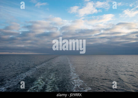 Kreuzfahrt Schiff Gefolge oder Trail auf der Meeresoberfläche, Spur in Horizont verschwinden. Wolken Himmel Stockfoto