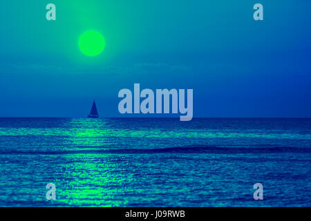 Am frühen Morgen, blau Sonnenaufgang über dem Meer. Segelboot am Horizont Stockfoto