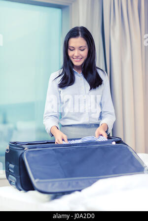 Geschäftsfrau Verpackung Dinge im Koffer Stockfoto