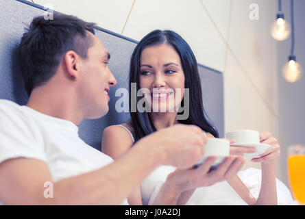 lächelnde paar frühstücken im Bett im hotel Stockfoto