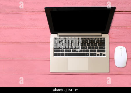 Notebook-Computer platziert auf einem rosa Holzboden in Konzepte, Technik und Wirtschaft. Stockfoto