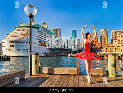 Strasse, tanzende Ballerina in Punkt Schuhe und rote Konzert Tutu auf einen Holzsteg in The Rocks historischen Hafen von Sydney gegen Circular Quay ein Stockfoto
